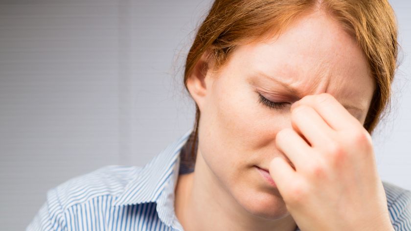 žena se drži za glavu